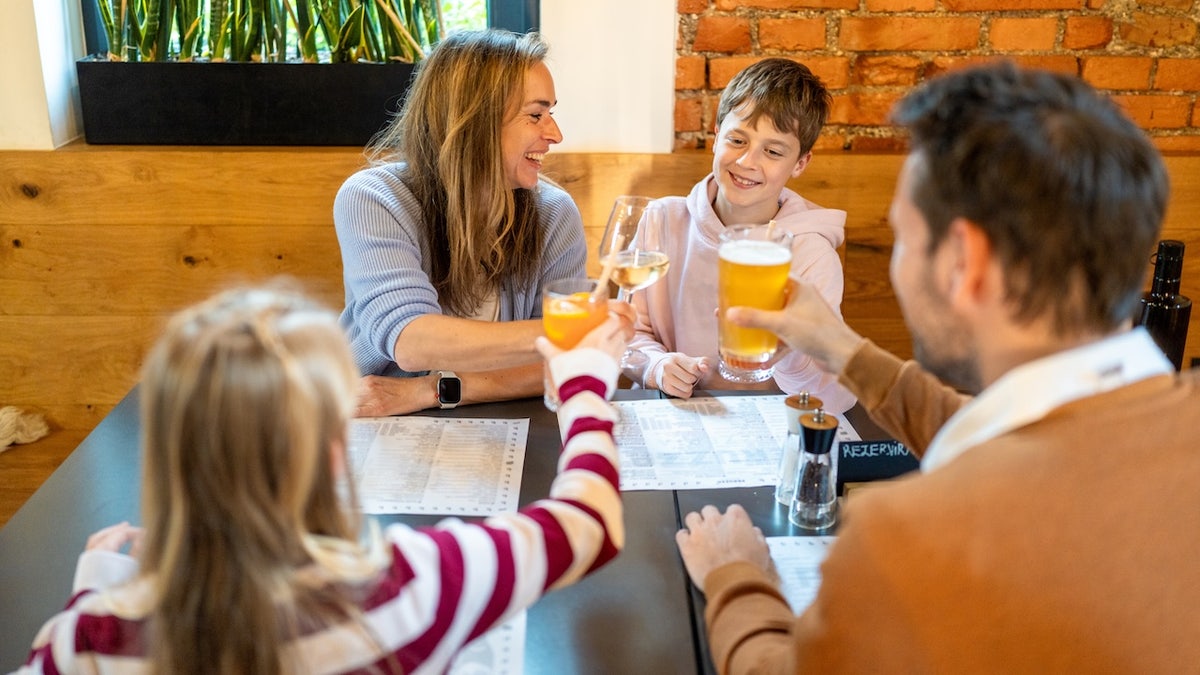 Parents drinking alcohol at table with kids