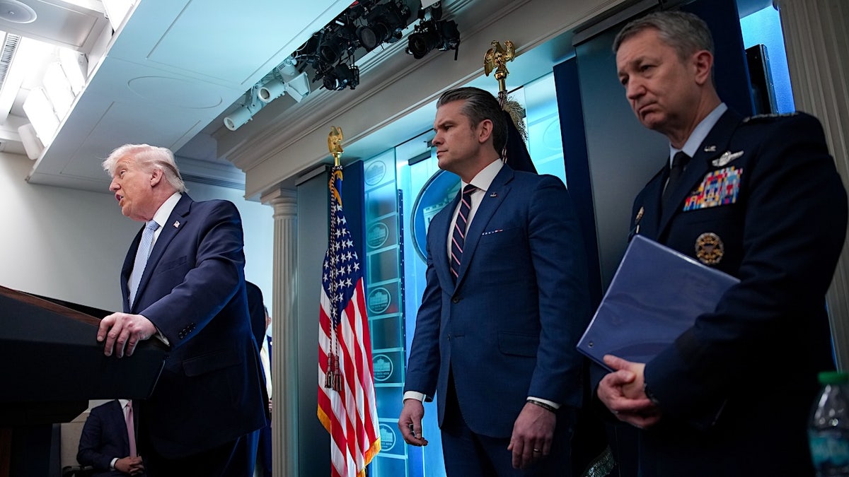 President Donald Trump speaking with Secretary of War Pete Hegseth and General Dan Caine in White House briefing room