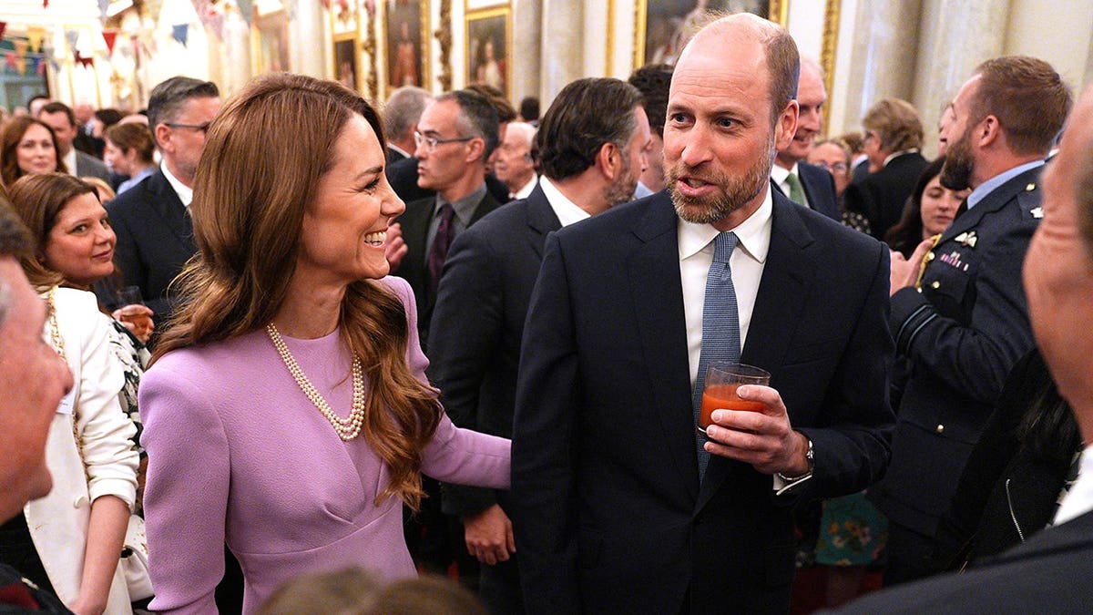 Princess Catherine and Prince William standing together at Buckingham Palace