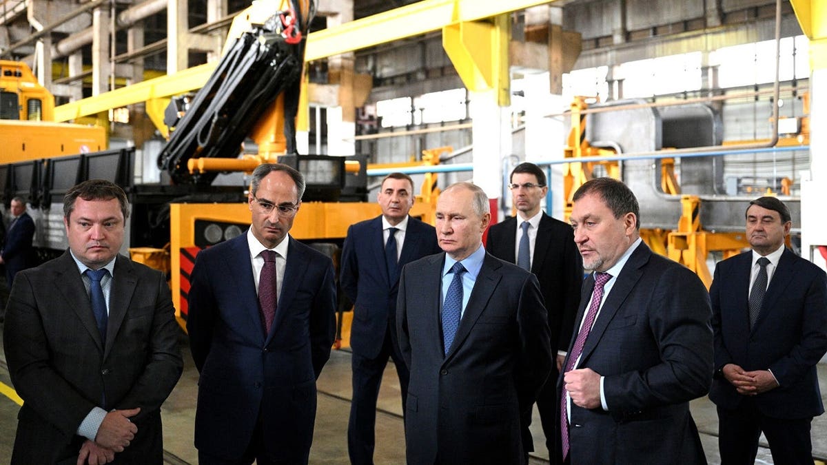 Russian President Vladimir Putin (C) inspects at facility of Tulazheldormash (Tula Railway Engineering Plant), manufacturer of heavy track equipment and equipment for the construction, renovation and maintenance of railway tracks, in Tula, Russia, on April 04, 2023.