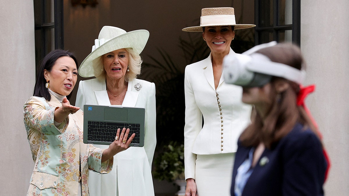 First lady Melania Trump en koningin Camilla kijken naar een student met een virtual reality-bril