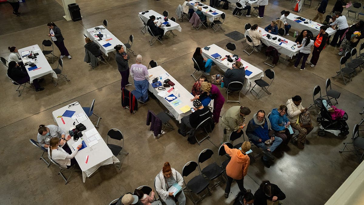 patients and volunteers sit at tables at clinic
