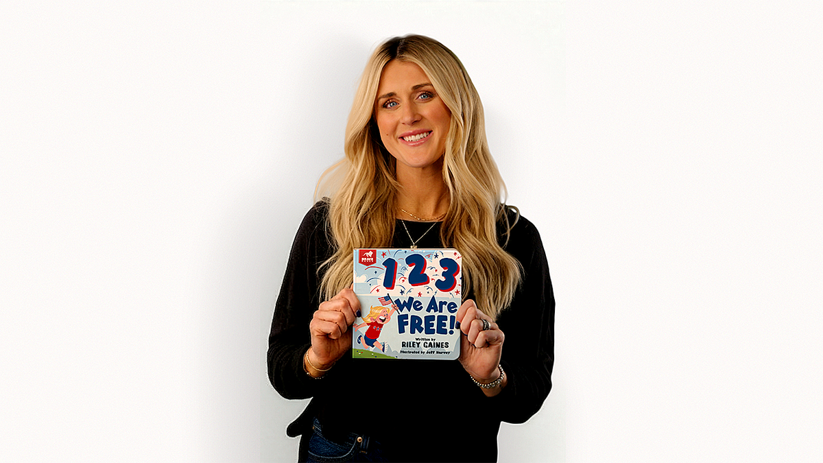 Riley Gaines holds up her new children's book in promotional photo.