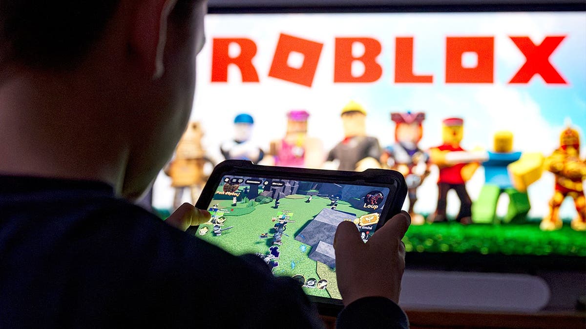 Child plays Roblox game on tablet device.