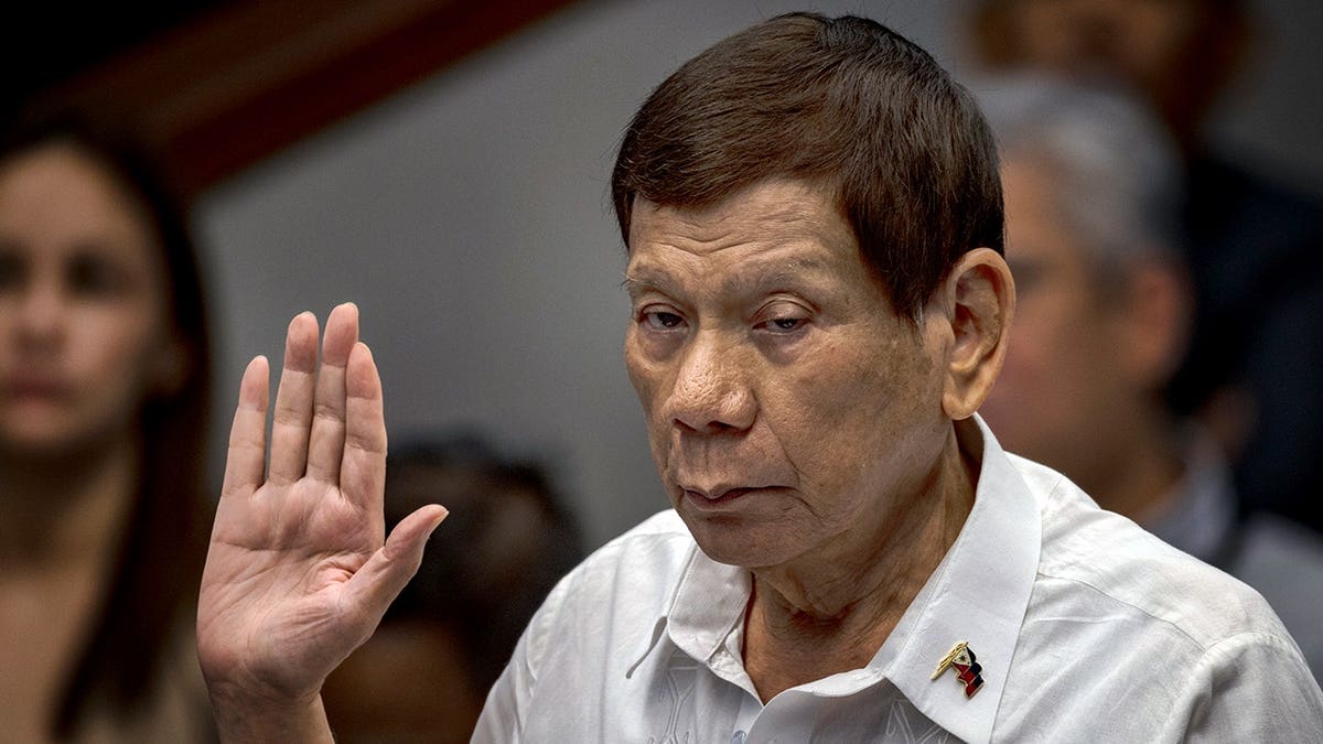 Rodrigo Duterte with his hand raised.