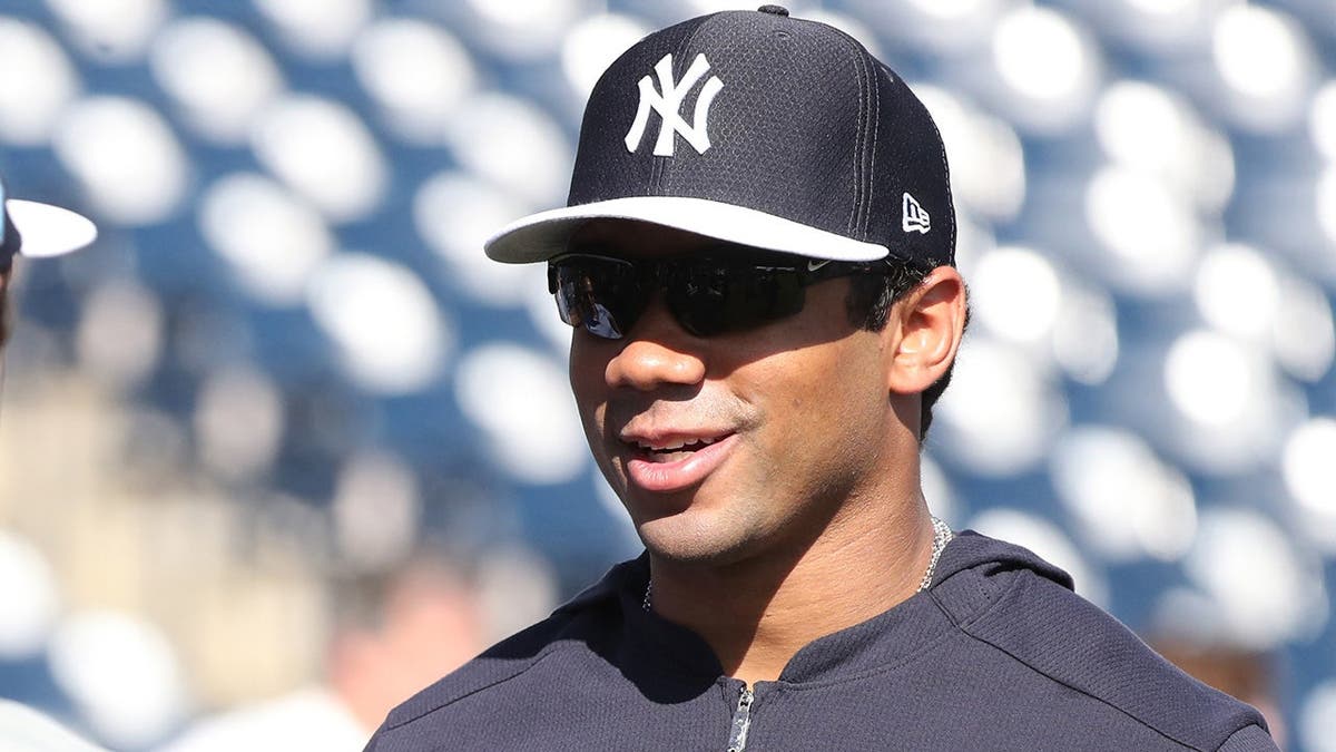 Seattle Seahawks quarterback Russell Wilson working out on a field.