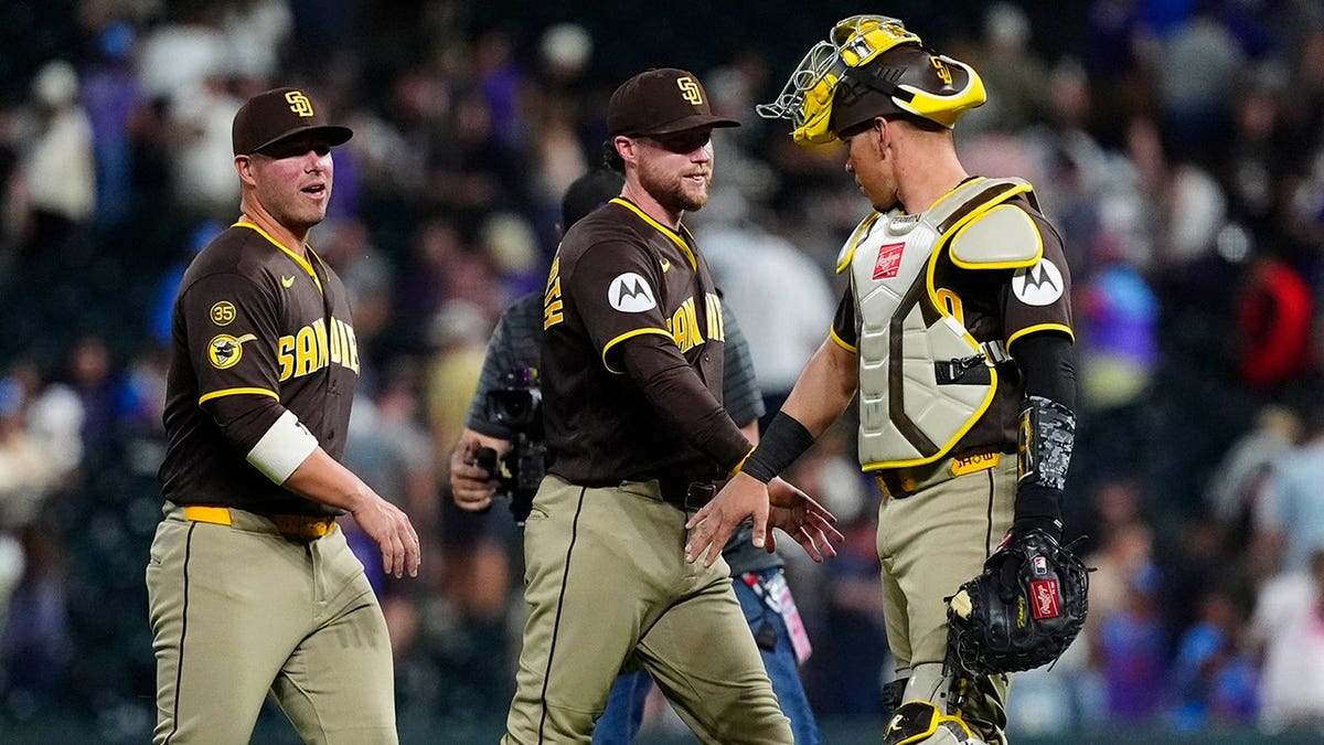 San Diego Padres players celebrating on the field at Coors Field in Denver