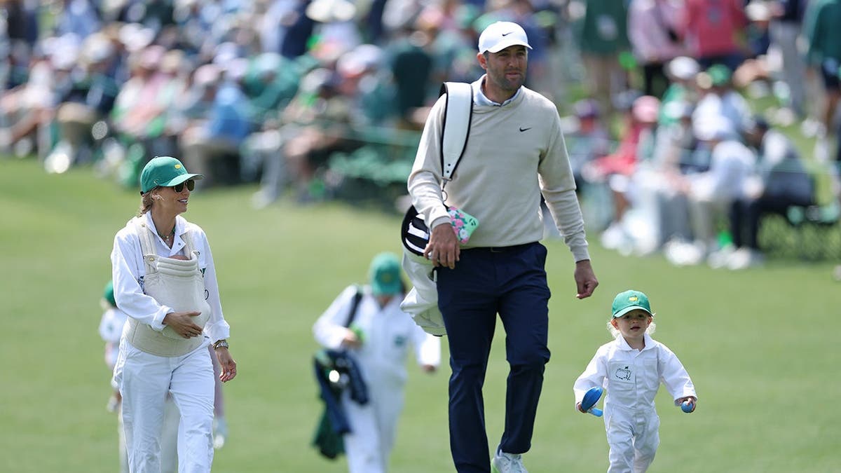 Scottie Scheffler walking with his lad   Bennett and woman  Meredith holding babe  Remy astatine  Augusta National Golf Club