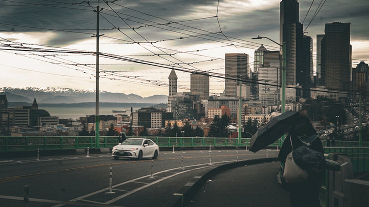 Seattle skyline visible from a road with buildings and water in the background