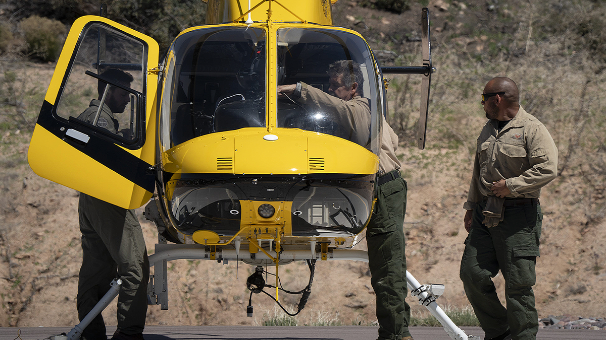 Gila County Sheriff’s deputies stand near a helicopter in Arizona