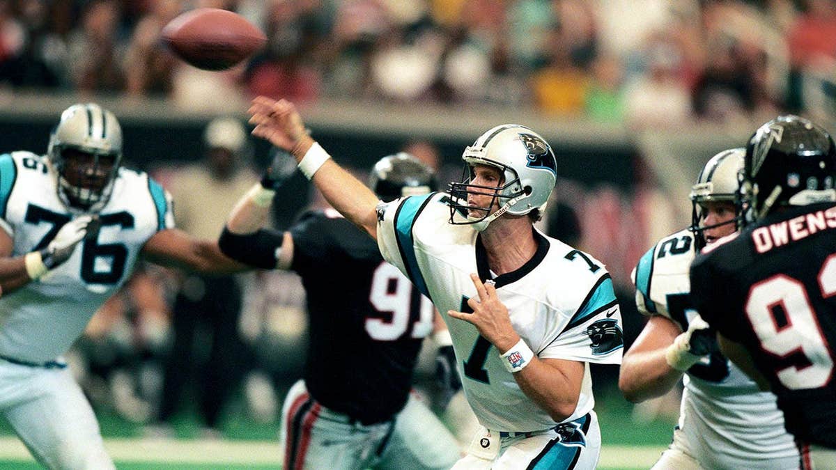Steve Beuerlein lancia un pallone da calcio durante una partita contro gli Atlanta Falcons