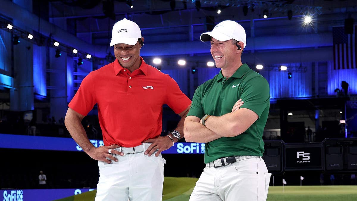 Tiger Woods and Rory McIlroy standing on golf course at SoFi Center