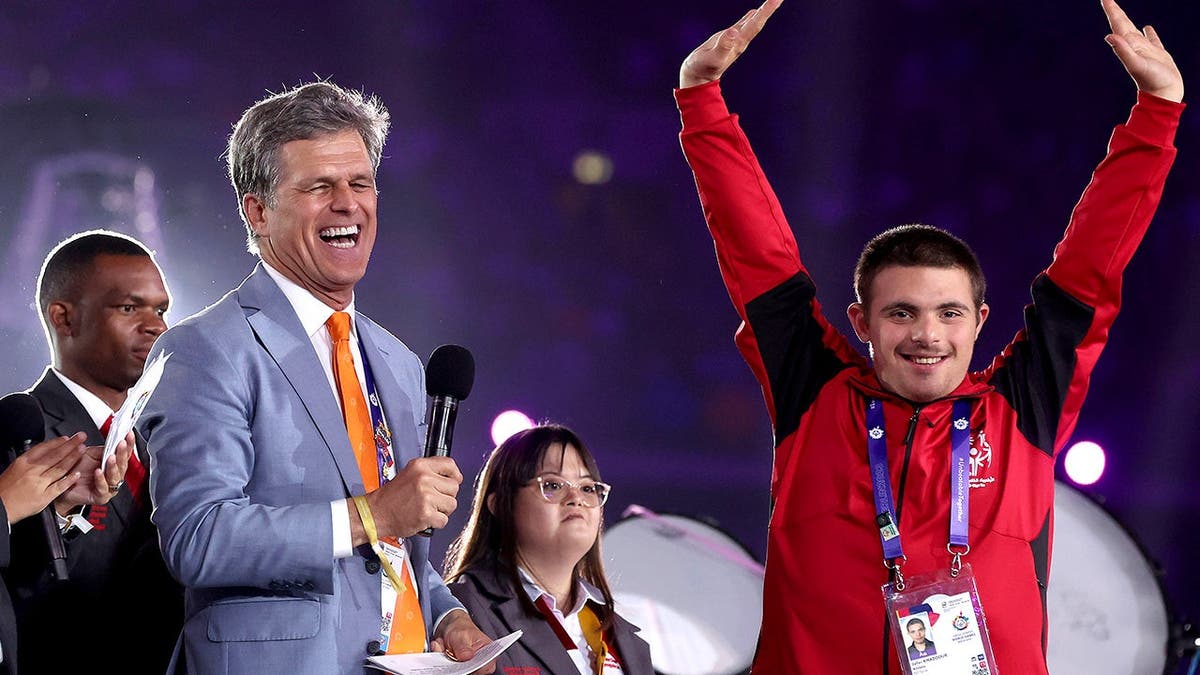 Timothy Shriver interacts with athlete at Special Olympics opening ceremony.
