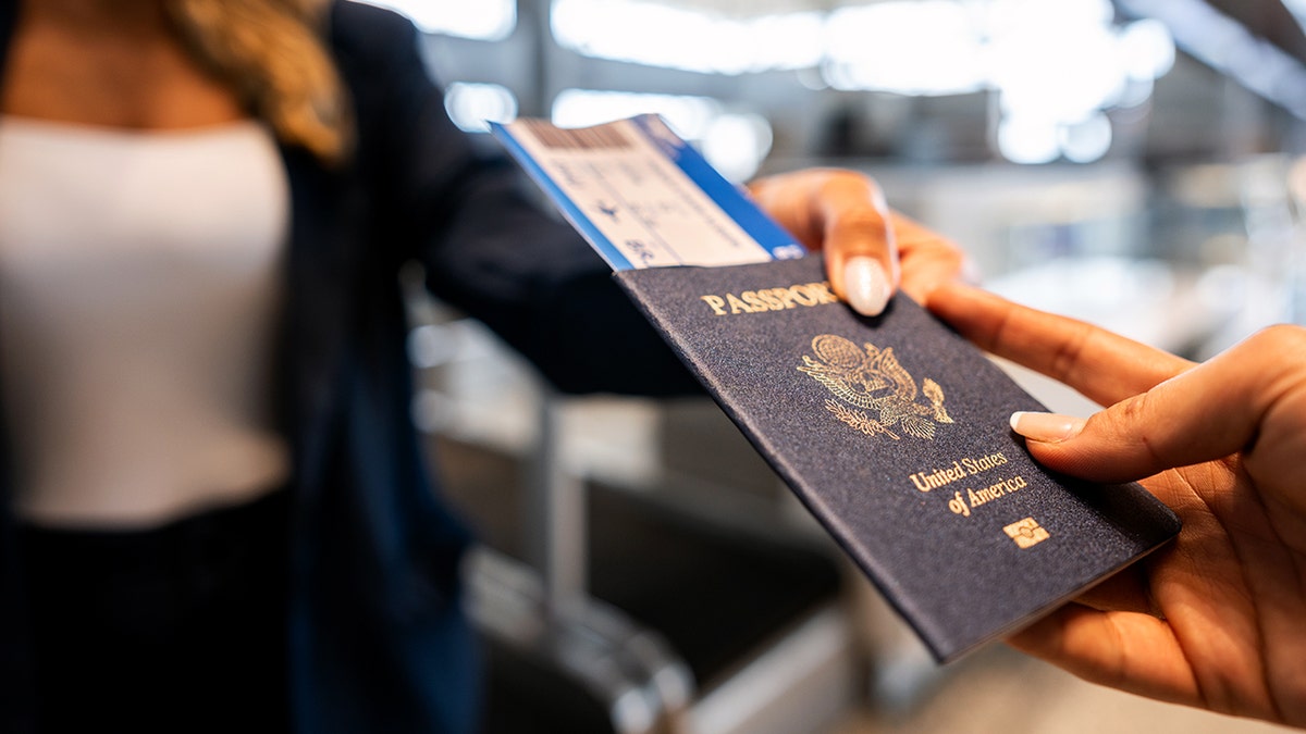 A woman hands over her passport.
