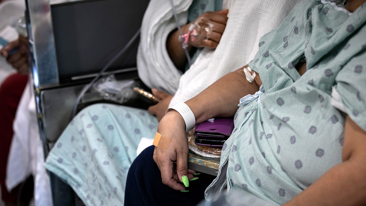 Dois pacientes estão sentados em roupas de hospital.