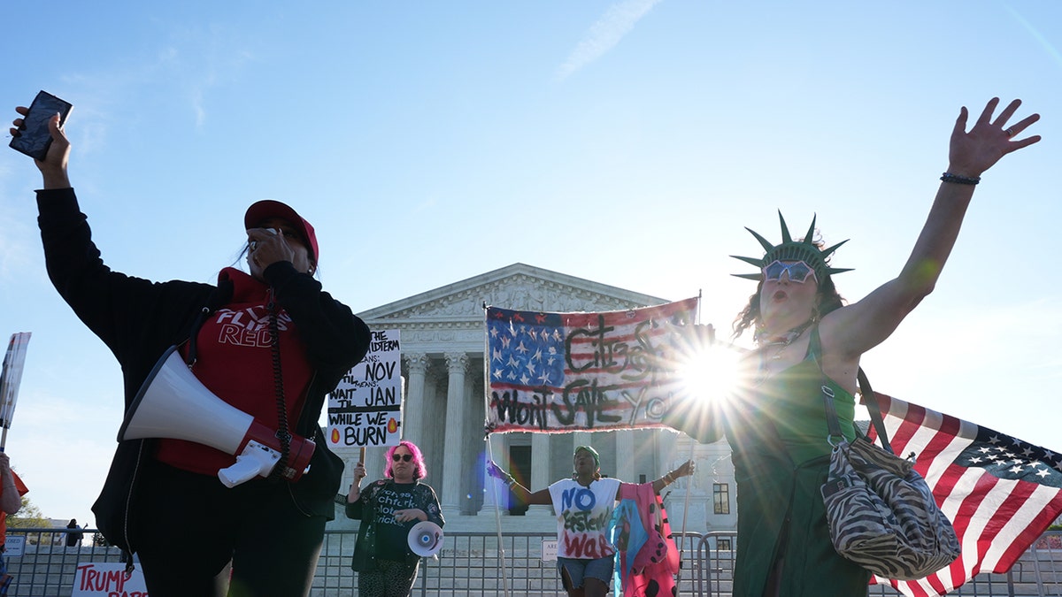 Pro and anti-Trump demonstrators rallying with signs outside the U.S. Supreme Court building.