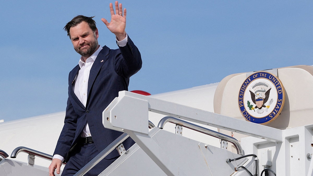 JD Vance walking down the stairs of Air Force Two at an airfield.