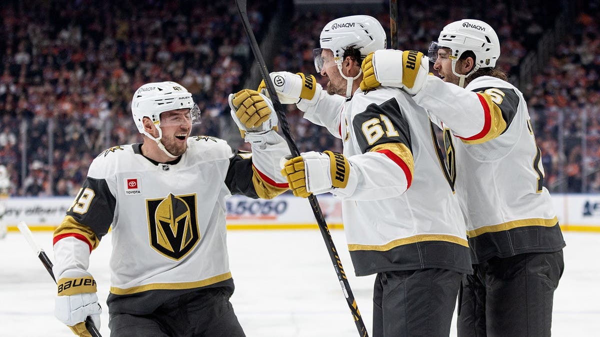 I giocatori dei Vegas Golden Knights Ivan Barbashev, Mark Stone e Noah Hanifin festeggiano un goal sul ghiaccio.
