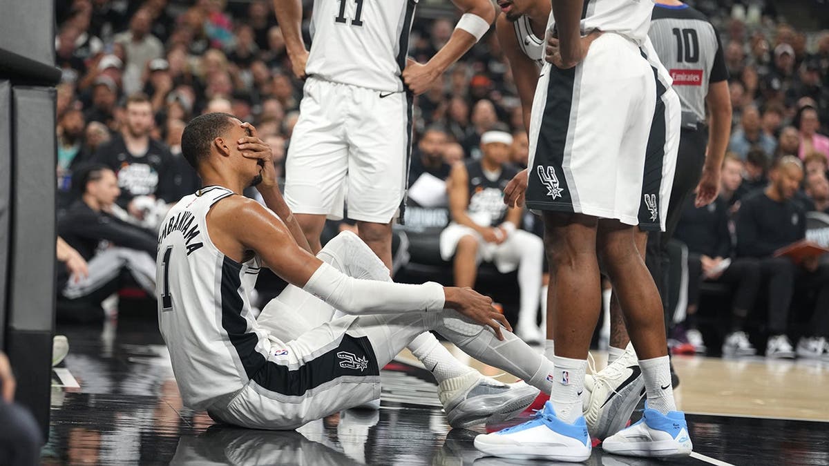 San Antonio Spurs forward Victor Wembanyama reacting beside guard Dylan Harper on the court.