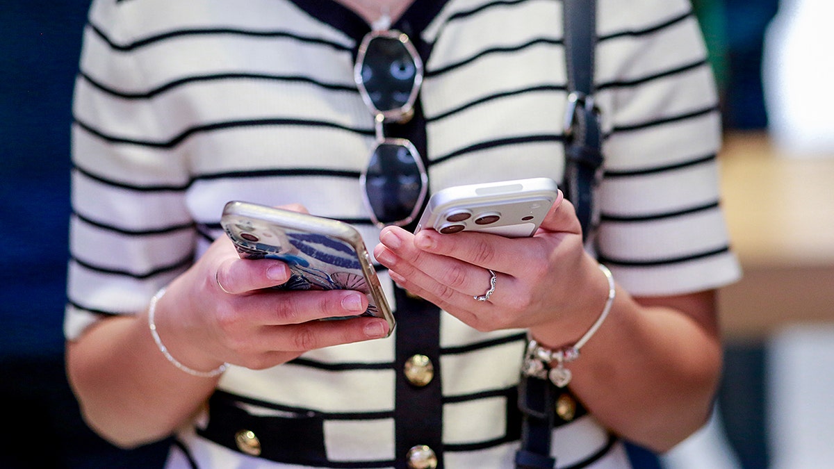 A customer holding a new iPhone inside Apple's Fifth Avenue store in New York City