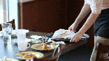 This animated image shows a server collecting a cash tip left at a restaurant table.