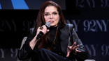 Debra Messing holds a mic