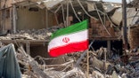 Iran flag over rubble