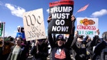 Demonstrators march near the Memorial Bridge during the No Kings protest in Washington, Saturday, March 28, 2026.