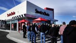 A crowd of about 30 people gathered in front of the Steak'n Shake in Centennial