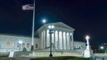 The U.S. Supreme Court building with the moon rising in the background in Washington