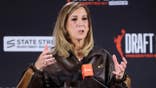 WNBA commissioner Cathy Engelbert speaking at a podium.