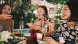 Women using mobile phones while dining at a restaurant.