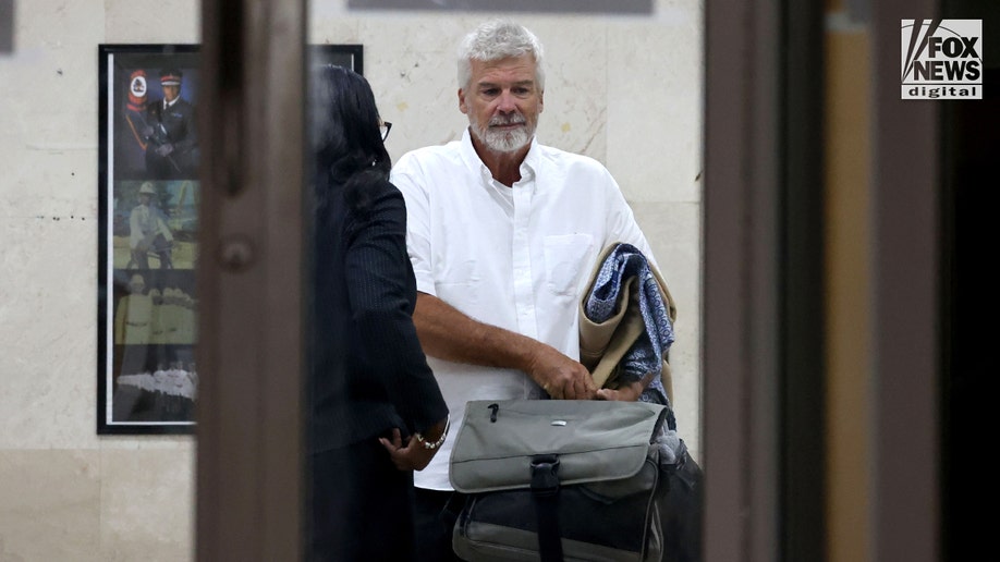 Brian Hooker leaves police station in The Bahamas, with lawyer.
