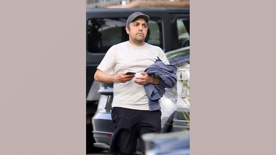 Eissa Hashemi, the son of an Iranian regime leader, walking in a parking lot