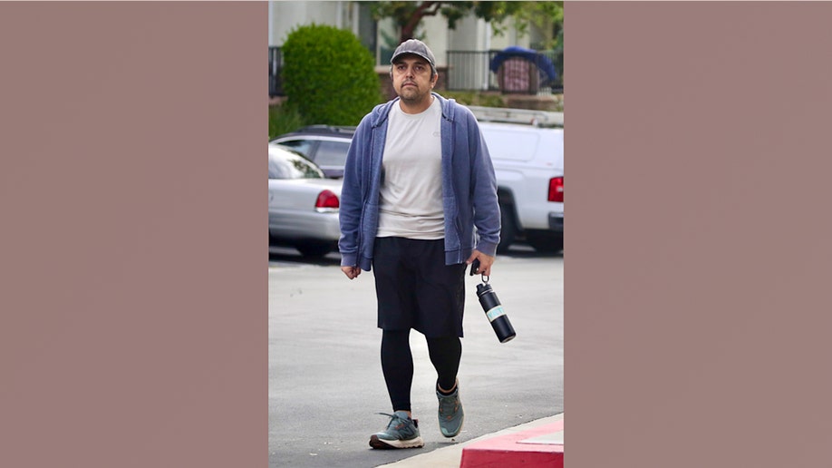 Eissa Hashemi, the son of an Iranian regime leader, walking in a parking lot