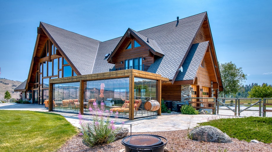 Back patio of ranch home with glass enclosure and outdoor seating