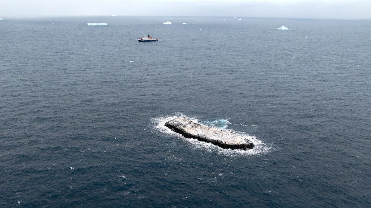 Aerial view of island with ship in the background