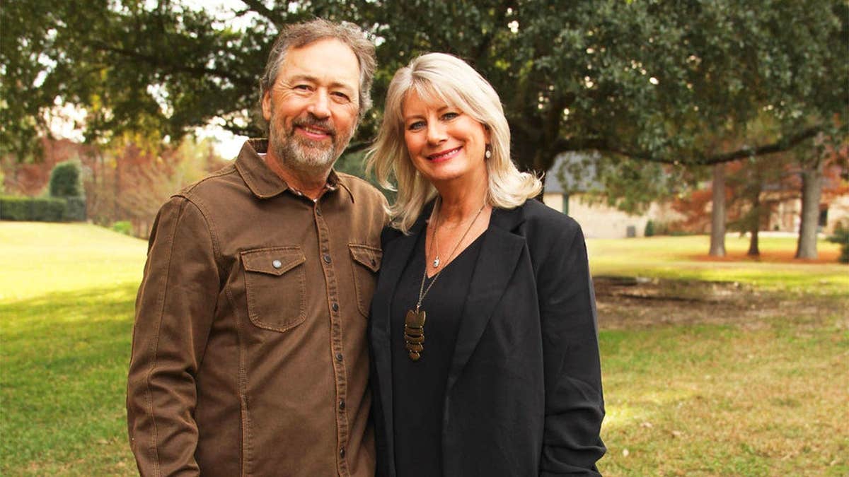 Al and Lisa Robertson posing together outdoors.