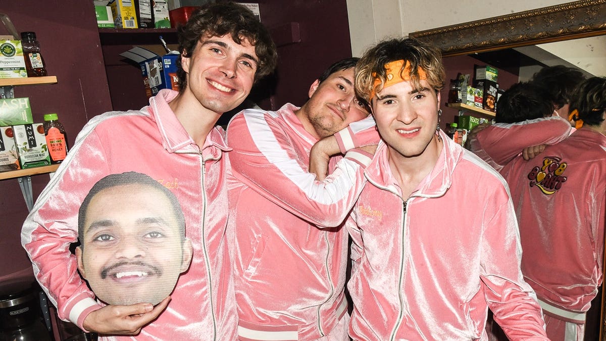 The U.S.-based members of Boy Throb gather, holding a Darshan Magdum fathead.