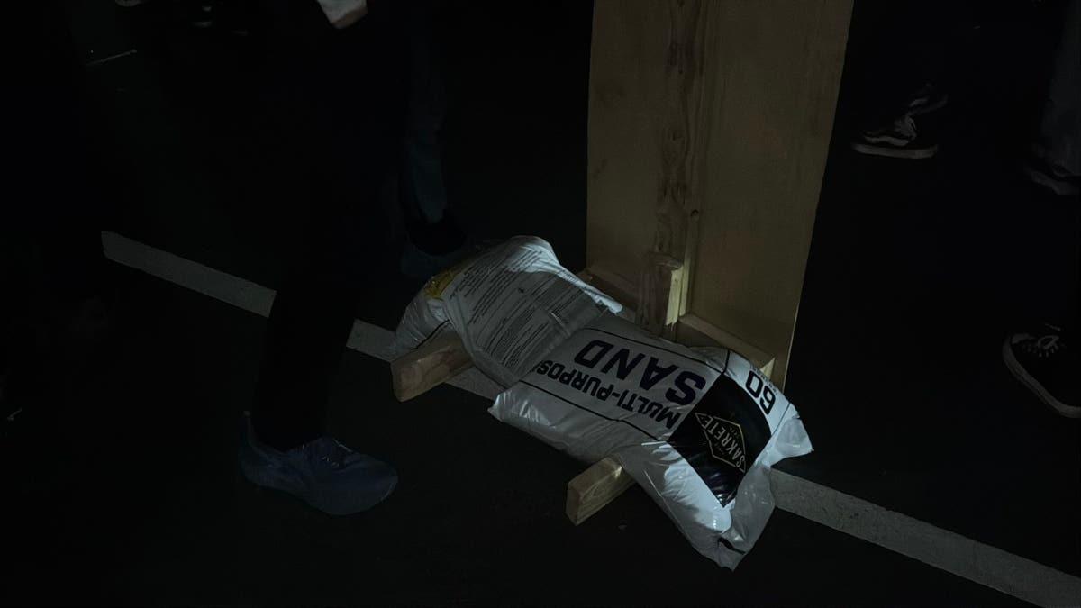 A sandbag being utilized  to reenforce  a barricade