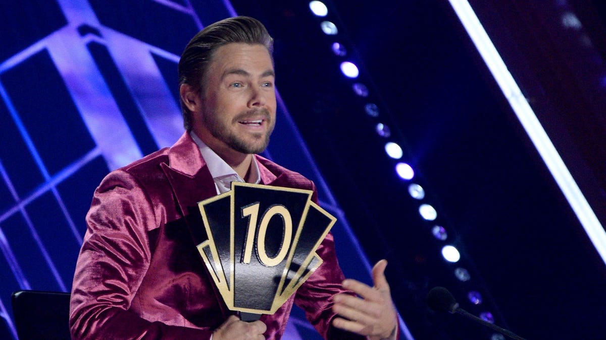 Derek Hough holds up a 10 during DWTS filming