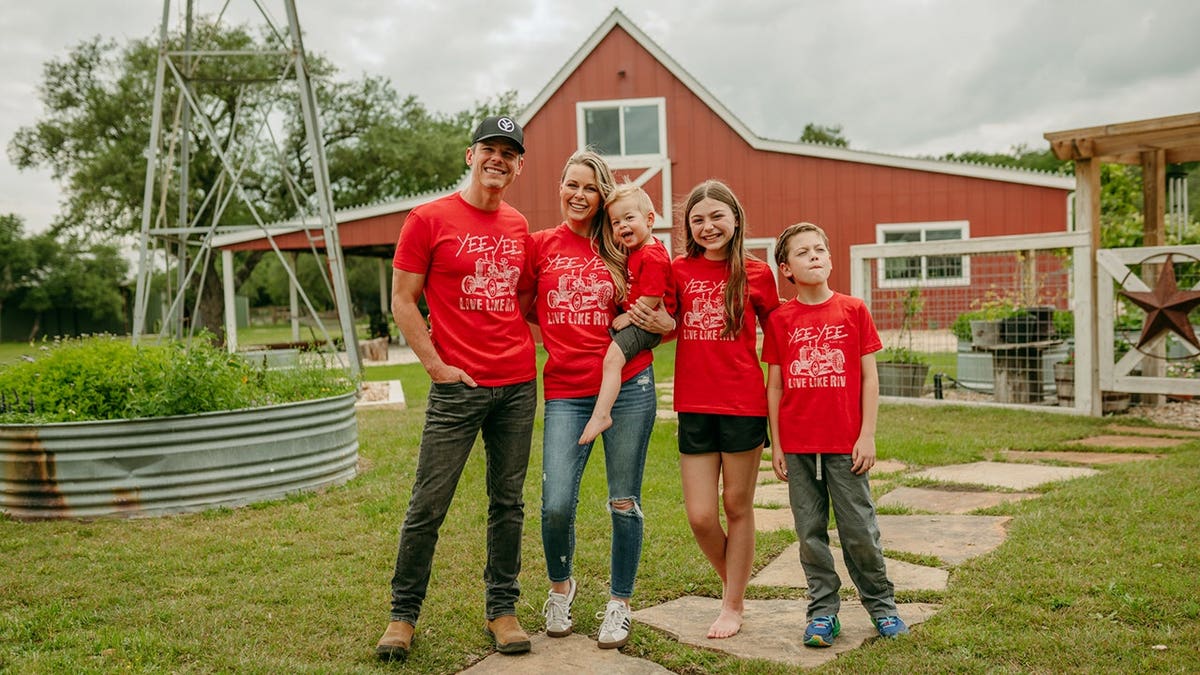 Granger Smith and his family were standing outside in front of the red house wearing matching red shirts.