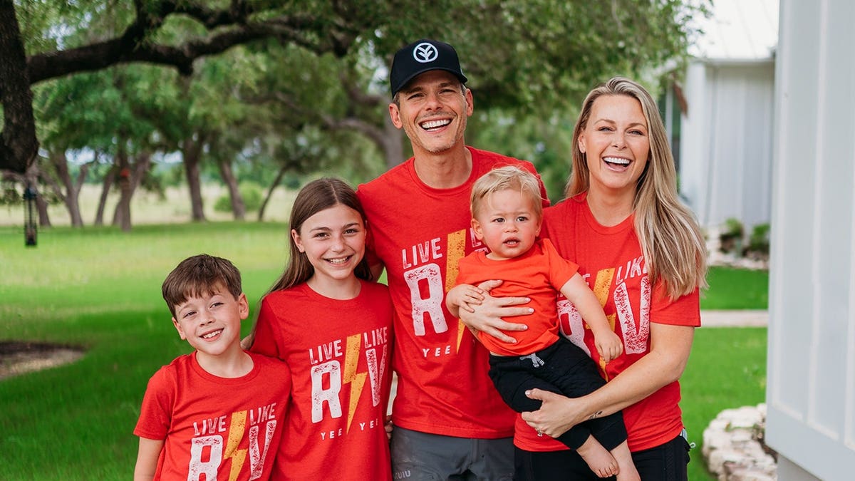 Granger Smith standing outside with his family as they all wore matching red shirts.