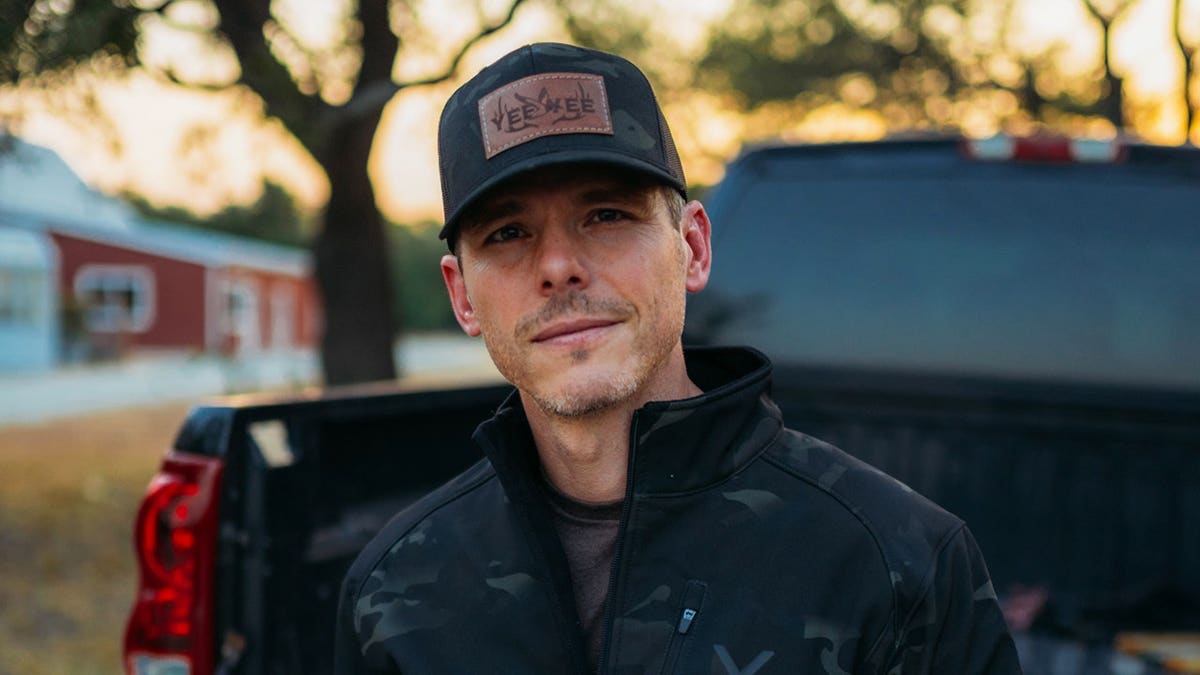 Granger Smith dressed in black and sitting in his truck.
