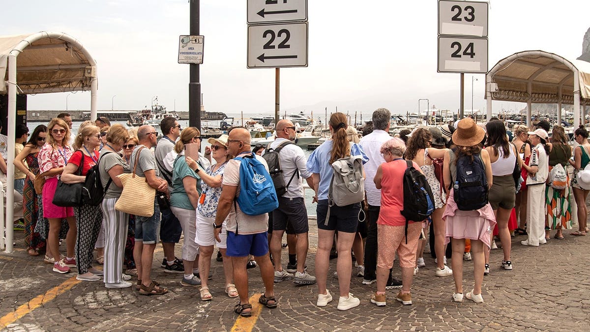 Crowd standing at bus stop in Amalfi Coast