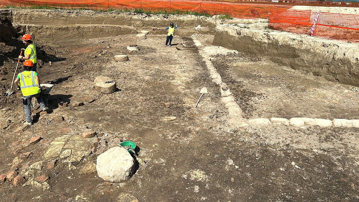 Wide shot of excavation area and ancient stones