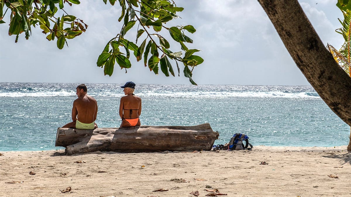Tourists sitting at beach in the Maldives
