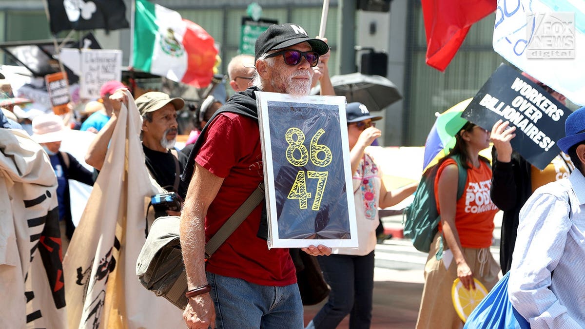 Man holds sign with slogan 