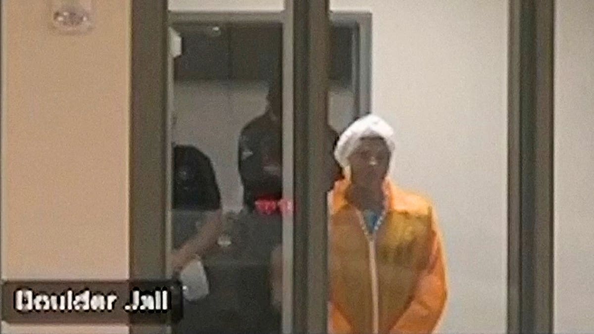 Boulder attack suspect Mohamed Sabry Soliman appears behind glass in the Boulder County Jail wearing an orange jumpsuit