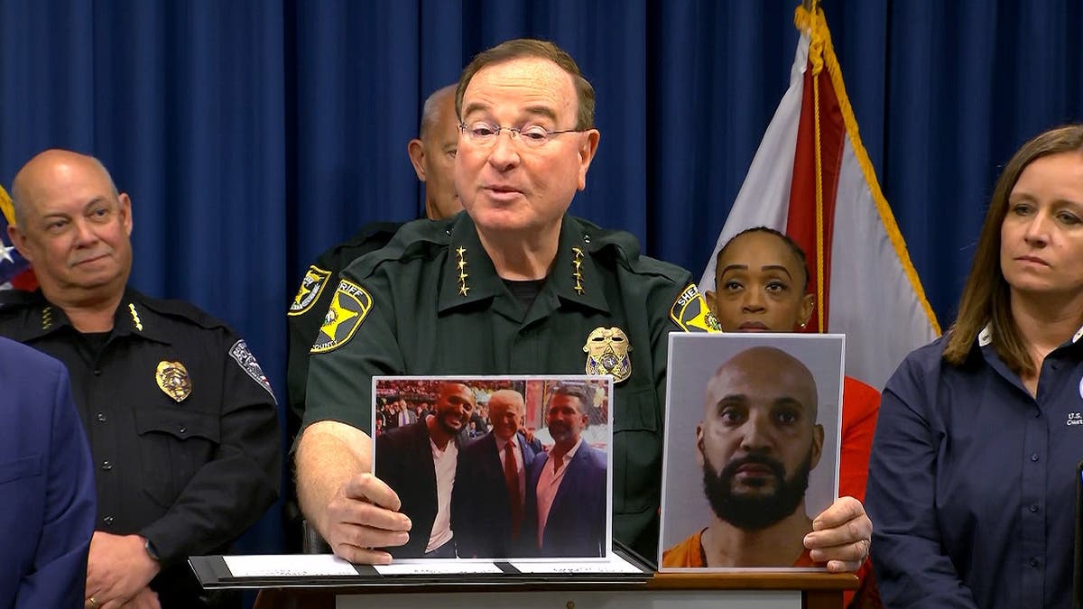 Sheriff Grady Judd holding a booking photo of Craig Long